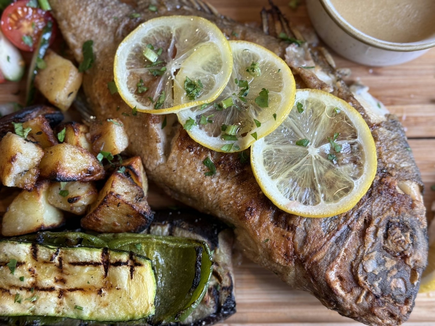 Robalo inteiro assado na brasa com legumes